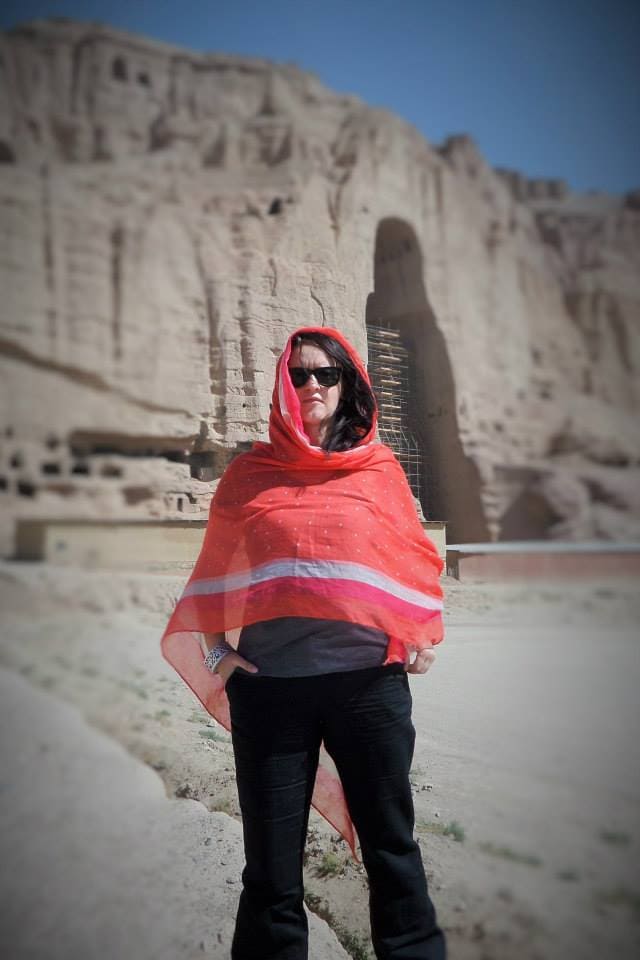 Diakonia CR Executive Director Kinga Komorowska stands in a desert setting with a gigantic sand rock behind her.